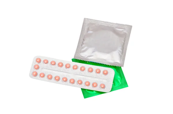 Оральные противозачаточные таблетки и презерватив изолированы на белом фоне — стоковое фото
