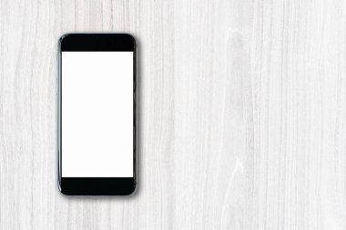 Boş beyaz ekran ve boşluk üzerinde tahta arka plan ile düz yatıyordu Smartphone