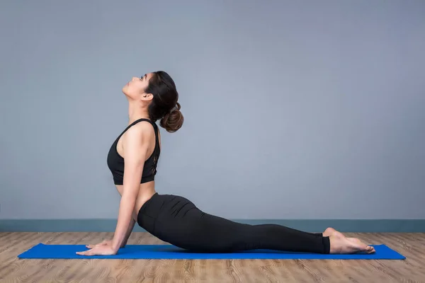 Jovem mulher asiática praticando ioga posar no ioga ginásio esporte saudável, ioga e meditação têm bons benefícios para a saúde. Conceito de foto para Yoga Sport e estilo de vida saudável . — Fotografia de Stock