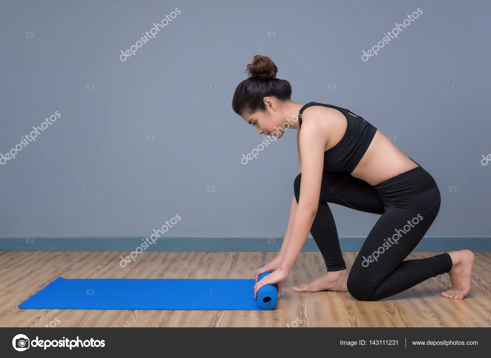 Young Asian Woman Preparing Yoga Mat For Practicing Yoga At Yoga