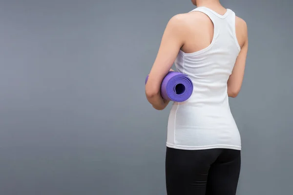 Young asian woman holding her yoga mat at yoga healthy sport gym. Yoga and meditation have good benefits for health. Photo concept for Yoga Sport and Healthy lifestyle. — Stock Photo, Image