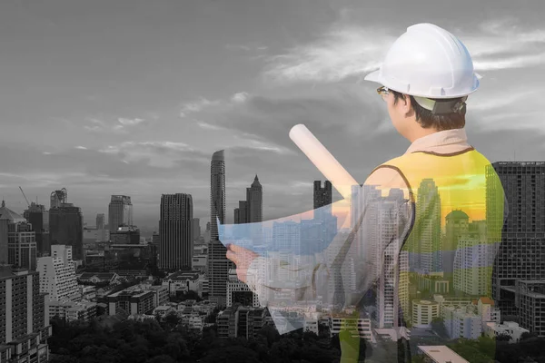 Doppelbelastung des Bauingenieurs bei der Überprüfung der Bauzeichnung und des modernen Stadtbildes in der Innenstadt — Stockfoto