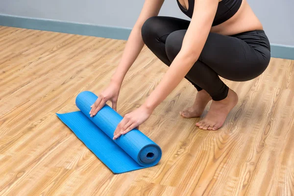 Jonge Aziatische vrouw bereiden haar yoga mat op indoor yoga gezonde sport sportschool — Stockfoto