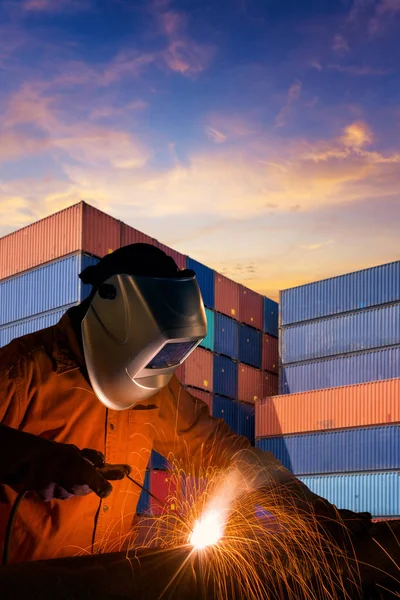 Industriell svetsning arbetare svetsning stål struktur med Last container stack i bakgrunden — Stockfoto