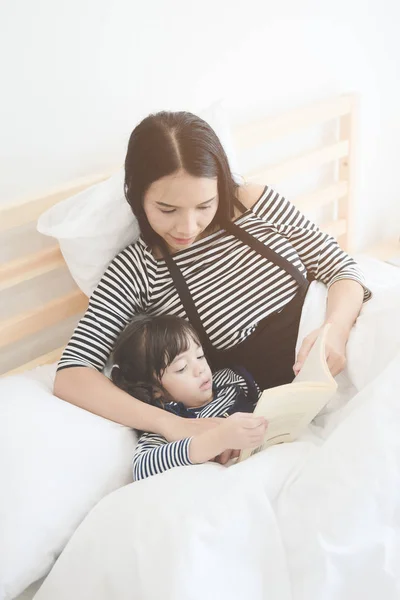 Boldog, szerető család fiatal ázsiai anya olvasott ágy idő story lányát a hálószobában — Stock Fotó