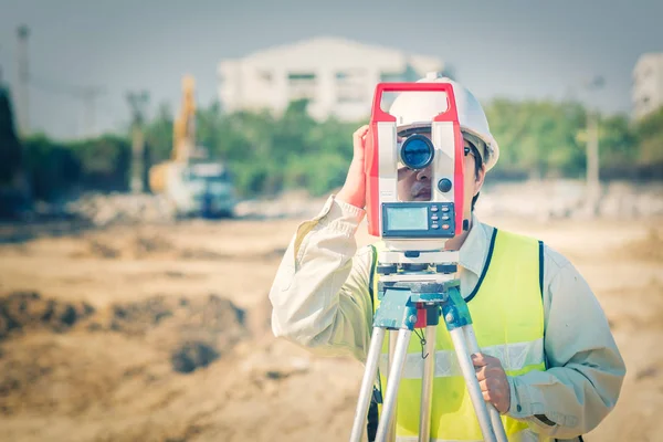 Építőmérnök használja földmérő eszközök teodolit ellenőrzési építkezés — Stock Fotó