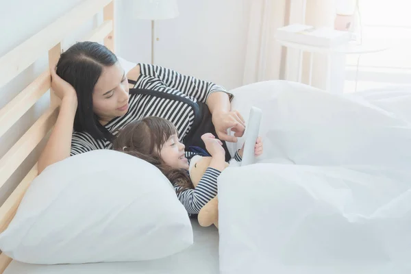 Boldog, szerető család, ázsiai fiatal anya nézte karikatúra a smart tábla a lányával, gyerek szoba. — Stock Fotó