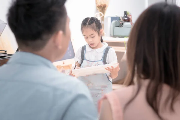 Азиатский отец и мать ищет дочь ребенка картина с акварелью на мольберте дома . — стоковое фото