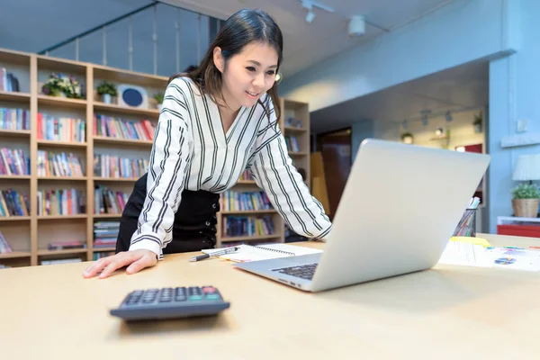 Ortak çalışma ofisinde akıllı bilgisayar üzerinde çalışan genç iş girişimci