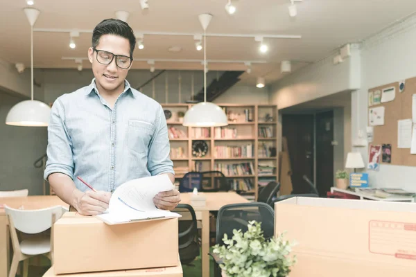 Jovem empreendedor asiático verificando documento no home office . — Fotografia de Stock