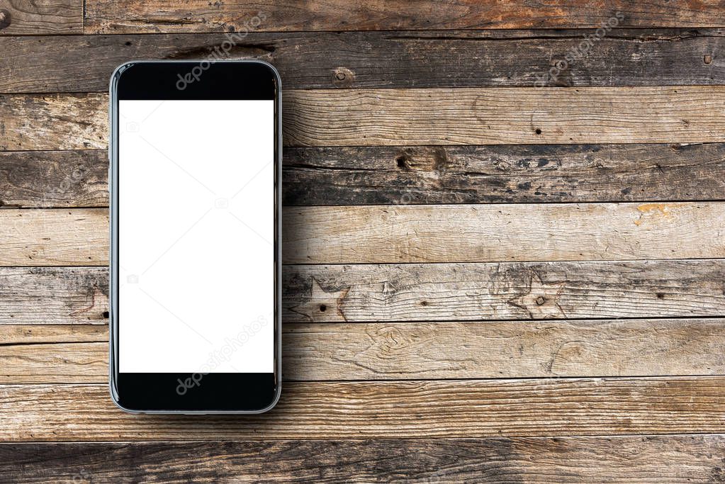 Flat lay Smartphone with blank white screen and copy-space on wooden table background. 