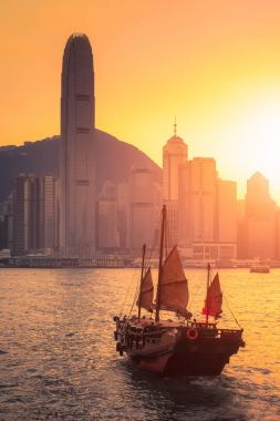 Hong Kong geleneksel turist tekne arka planda şehir manzaralı victoria Harbor turistik hizmet için gün batımında, Hong Kong, Kowloon yan görünümden