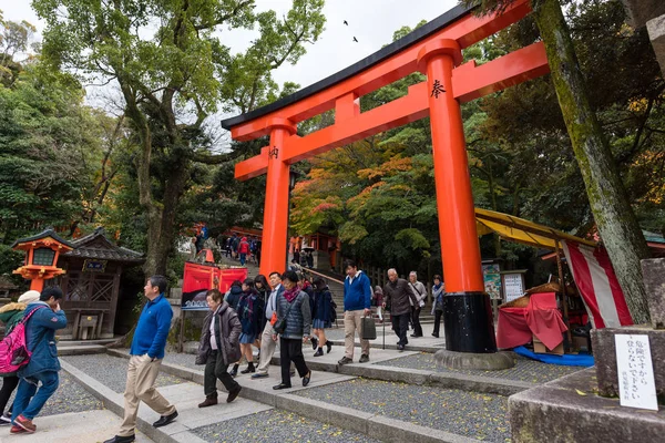 Turistas en el camino rojo torii puertas pasarela en fushimi inari taisha santuario el de lugares de interés turístico en Kyoto, Japón . — Foto de Stock