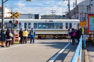 Çalışan Japon Jr tren bekliyorsun kişi yol kavşak geçiş