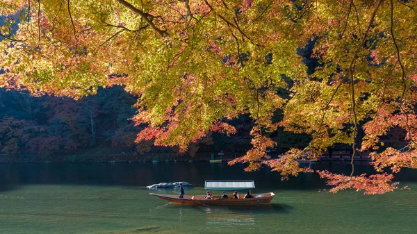 Turistas não identificados em barcos de madeira desfrutam de cores de outono ao longo do rio Hozu gawa em Arashiyama, em Kyoto — Fotografia de Stock