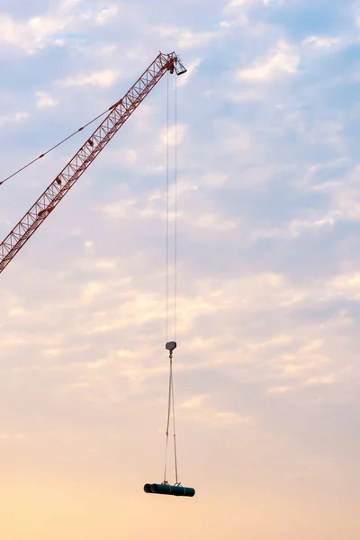 Industriella tunga kran lyft stålkonstruktion på byggarbetsplats med sunset himmel bakgrund. — Stockfoto