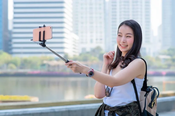 在市中心的城市里，美丽的亚洲女游客通过智能手机使用视频通话. — 图库照片