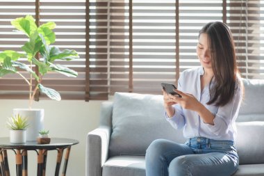 Güzel bir kadın evinde güvende olduğu sürece arkadaşlarıyla çevrimiçi sohbet etmek için cep telefonu ve internet teknolojisi kullanıyor.