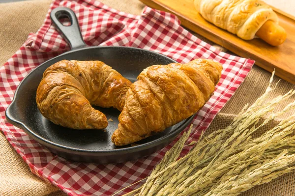 Kruvasan fab üzerinde koymak siyah seramik tava üzerinde iki adet
