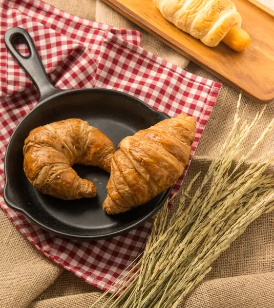 Kruvasan fab üzerinde koymak siyah seramik tava üzerinde iki adet