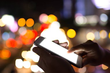 İki el bir smartphone parlak beyaz monitör ile oynayan adam