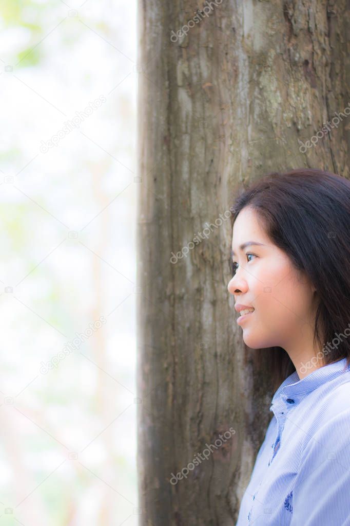 Woman is standing close to the tree feel relax by her eys that l