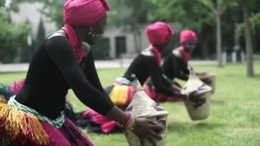 Sepetleri ile geleneksel kostümleri bir halk dansları dans üç Afrikalı kadınlar