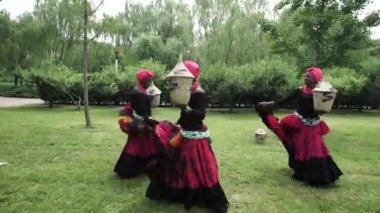 Sepetleri ile geleneksel kostümleri bir halk dansları dans üç Afrikalı kadınlar
