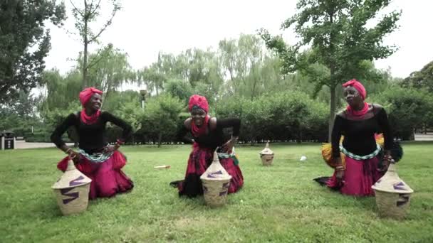 Drei afrikanische Frauen tanzen einen Volkstanz in traditionellen Trachten mit Körben — Stockvideo