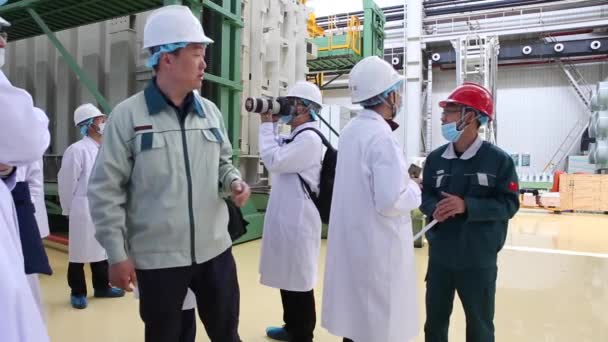 En utflykt till fabriken i Shaghai, Kina 4 dec 2017, människor i vita kläder går genom fabriken verkstaden som gör transformatorer — Stockvideo