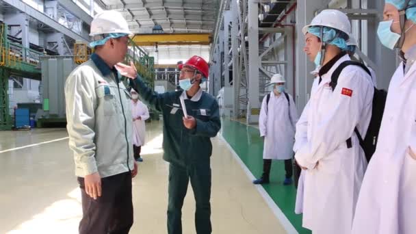 Экскурсия на фабрику в г. Шагай, Китай 4 декабря 2017 года, люди в белых халатах проходят через заводскую мастерскую, которая производит трансформаторы — стоковое видео