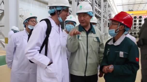 Uma excursão para a fábrica em Shaghai, China 4 de dezembro de 2017, as pessoas em vestes brancas passam pela oficina da fábrica, que faz transformadores — Vídeo de Stock
