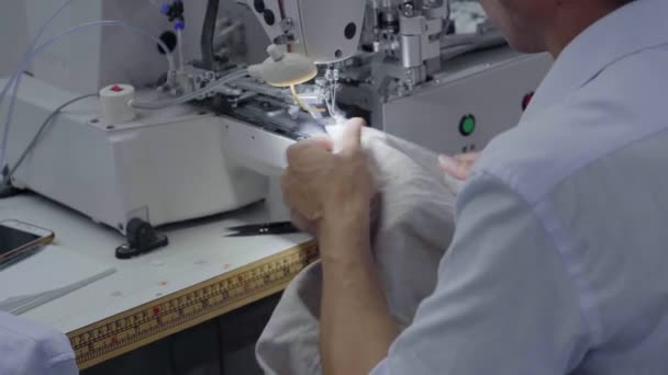 Шитье пуговиц на футболках у специальной автоматизированной печатной машины — стоковое видео