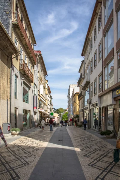 Blick auf eine Straße mit klassischen Gebäuden in der Innenstadt von Viseu, Menschen gehen und speichern Gebäude, Symbol der Stadt Viseu — Stockfoto