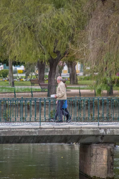 Veduta di un ponte pedonale con persone a piedi, oltre parchi lago sulla città di Tomar centro, Portogallo — Foto Stock