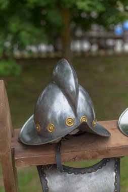 Ortaçağ aksesuarının detaylı görüntüsü, tahta kirişe tünemiş şövalye metal miğferi.