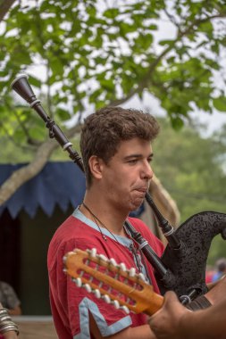 Ortaçağ enstrümanları çalan ve ortaçağ enstrümanları çalan müzisyenlerle Celtic Gayda çalan bir müzisyenin ayrıntılı görüntüsü, açık hava Kelt müzik konseri
