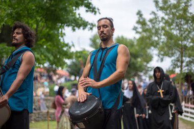 Ortaçağ kıyafetleri içinde ortaçağ enstrümanları çalan müzisyenlerin, ortaçağ fuarında seyircilerin izlediği açık hava Kelt müzik konseri