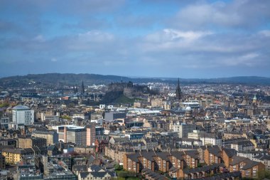 Holyrood Parkı 'ndan Edinburgh şehir merkezine genel hava manzarası, arka planda anıt binalar, dağlar ve parklar