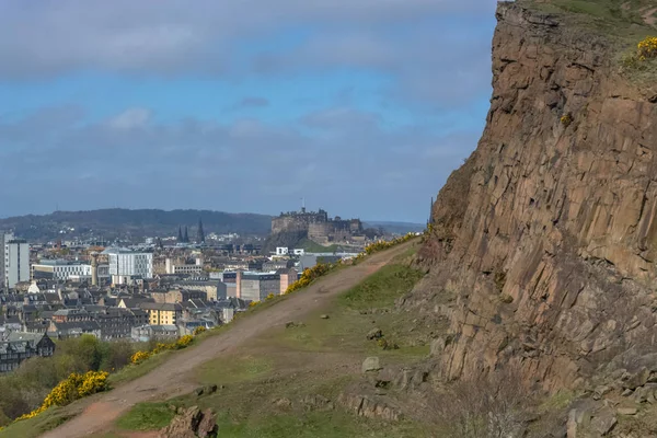 General aerial view from the Holyrood Park to the Edinburgh downtown city, monument buildings, mountains and parks on background — Stock Photo, Image