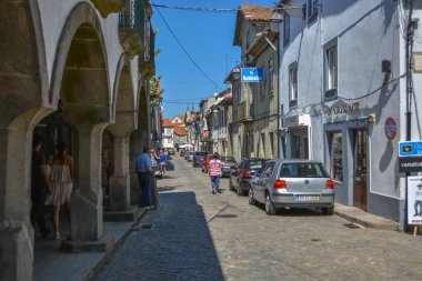 Trancoso duvarları, binalar, arabalar ve insanlarla güçlendirilmiş ortaçağ şehrinin iç manzarası.