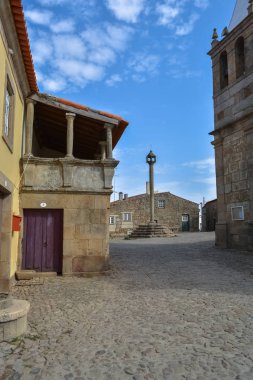 Castelo Mendo Kalesi 'nin içindeki ortaçağ köyüne bakın. Pillori ve ortaçağ binalarıyla dolu bir plaza.