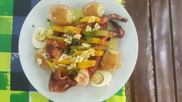 Vista di un pasto tipico portoghese, piatto con polpo alla griglia, patate, uova e aglio, in Portogallo si chiama polvo lagareiro — Foto Stock