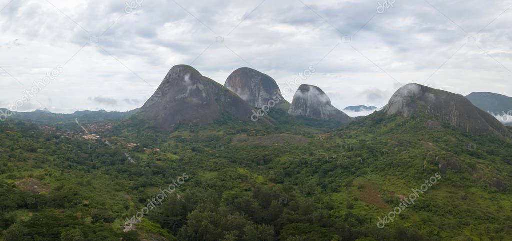 Aerial Photography of a tropical landscape, with forest and mountains Kumbira forest reserve , huge geologic rock elements, cloudy sky as background, on Conda, Sumbe, Angola