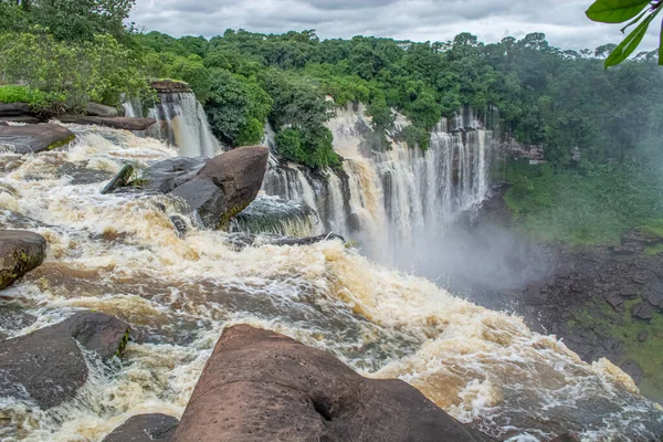 Lucala nehrindeki Kalandula şelalesinin manzarası, tropikal orman ve Angola 'daki bulutlu gökyüzü.