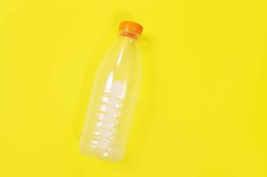 Sarı arka plandaki boş plastik şişe, ekoloji.