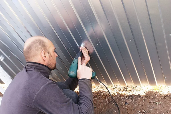 Tornavidalı adam çiti tamir ediyor.