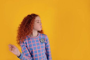 Sarı arka planda güzel kızıl saçlı kız.