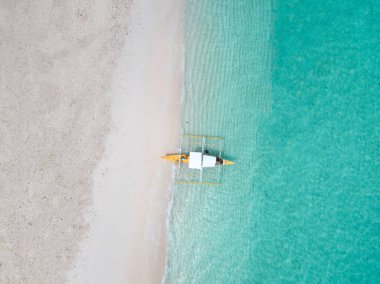 Üzerinde geleneksel filippine tekneleri olan beyaz kumsal manzarası.