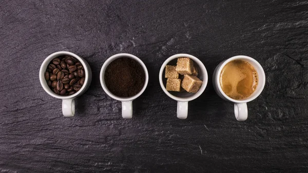 Tazas llenas de granos de café, café molido, azúcar morena y espres — Foto de Stock